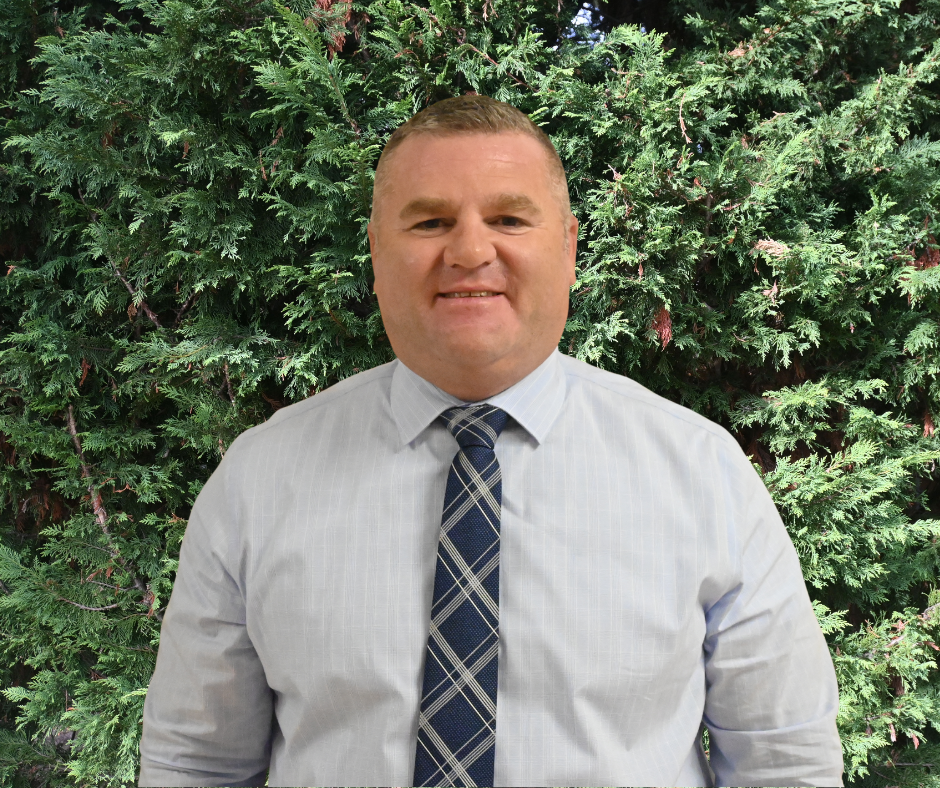 man standing in front of bushes